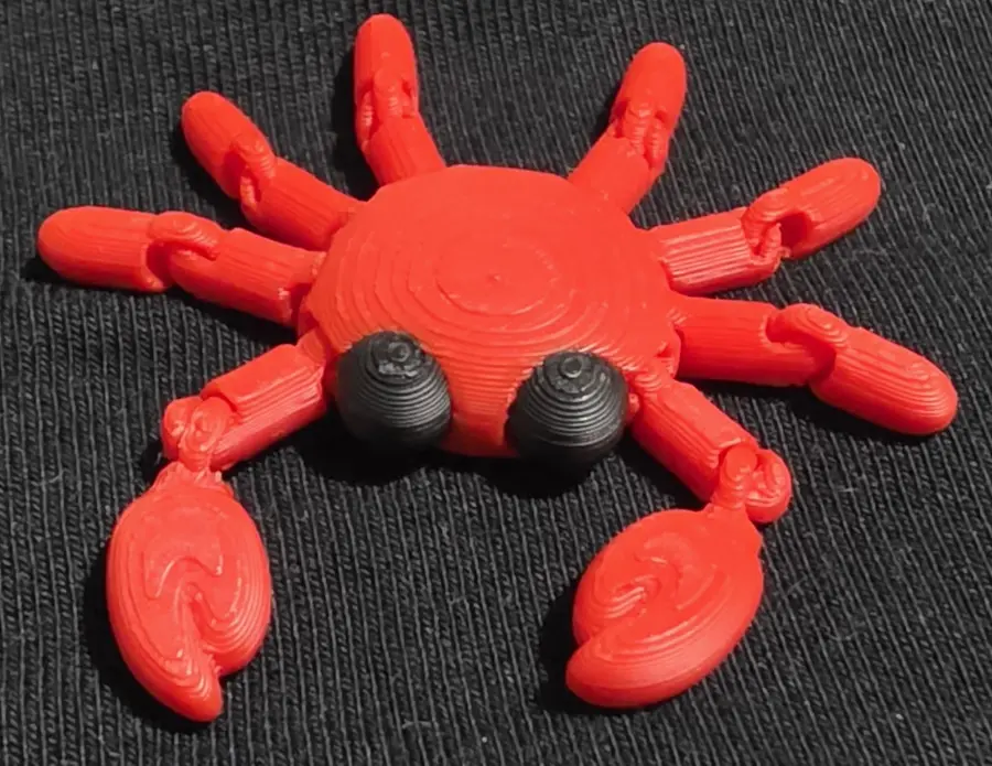 Red articulated crab fidget, angled view