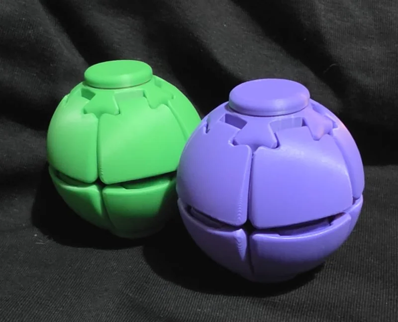 Fidget spinner ball, green and purple, angled view